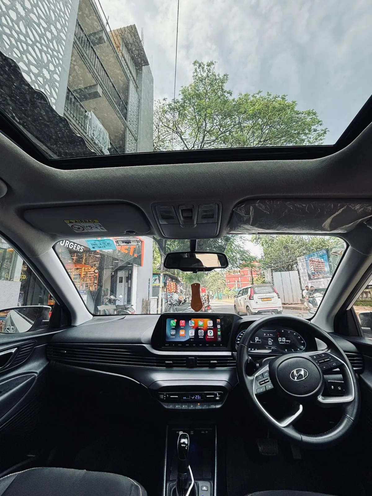 Interior and dashboard of the Hyundai i20, showcasing the sunroof. Book this car for rent in Goa.