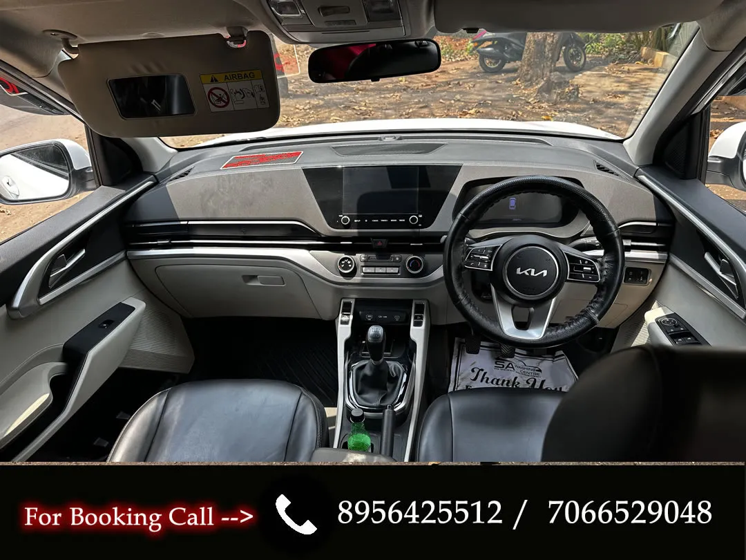 Dashboard and front seats of the KIA Carens, book this 7-seater for your Goa trip.