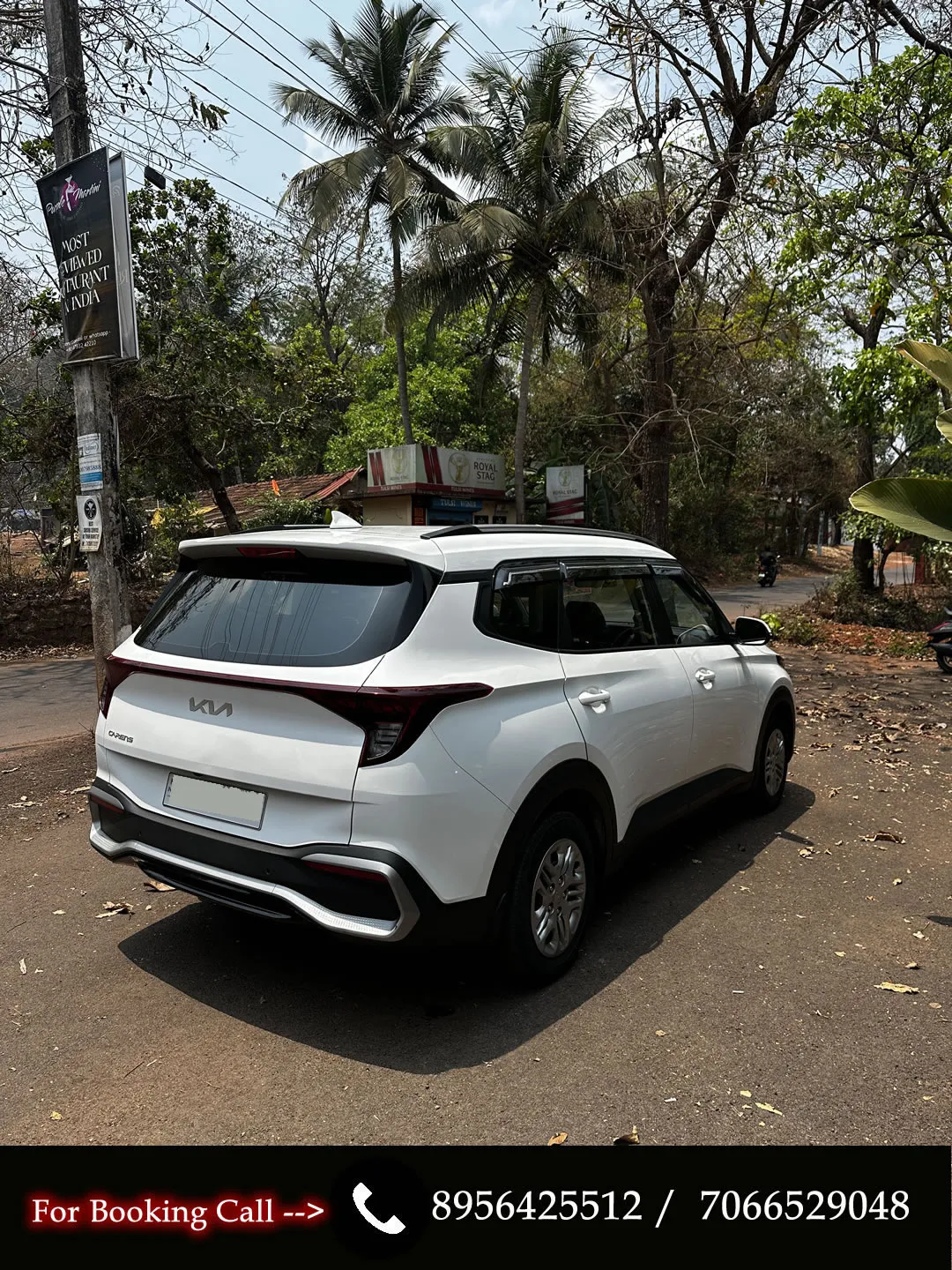 Left rear angle of the manual KIA Carens, ideal for family trips in Goa.