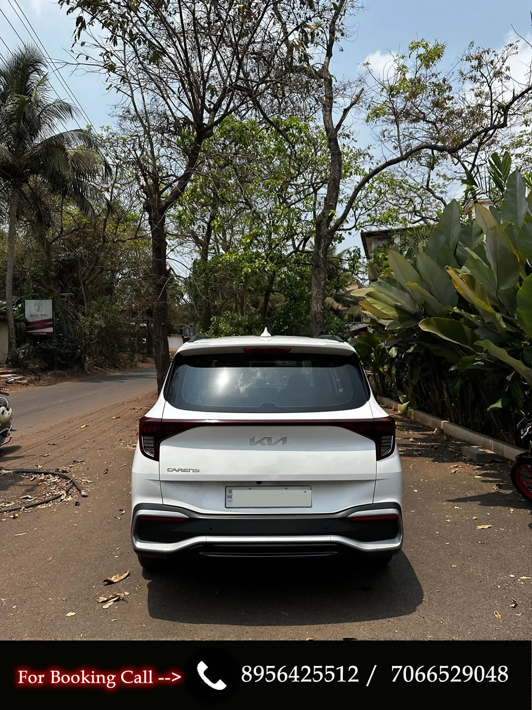 Back view of the manual KIA Carens, a reliable MPV for rent in Goa.